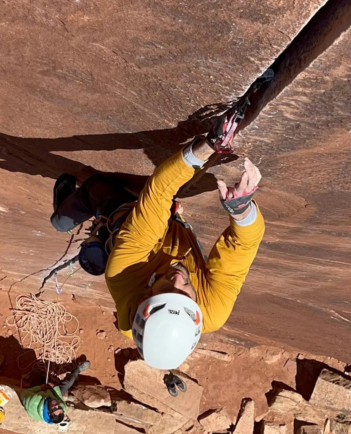 Escalador usando guantes para escalar fisuras.